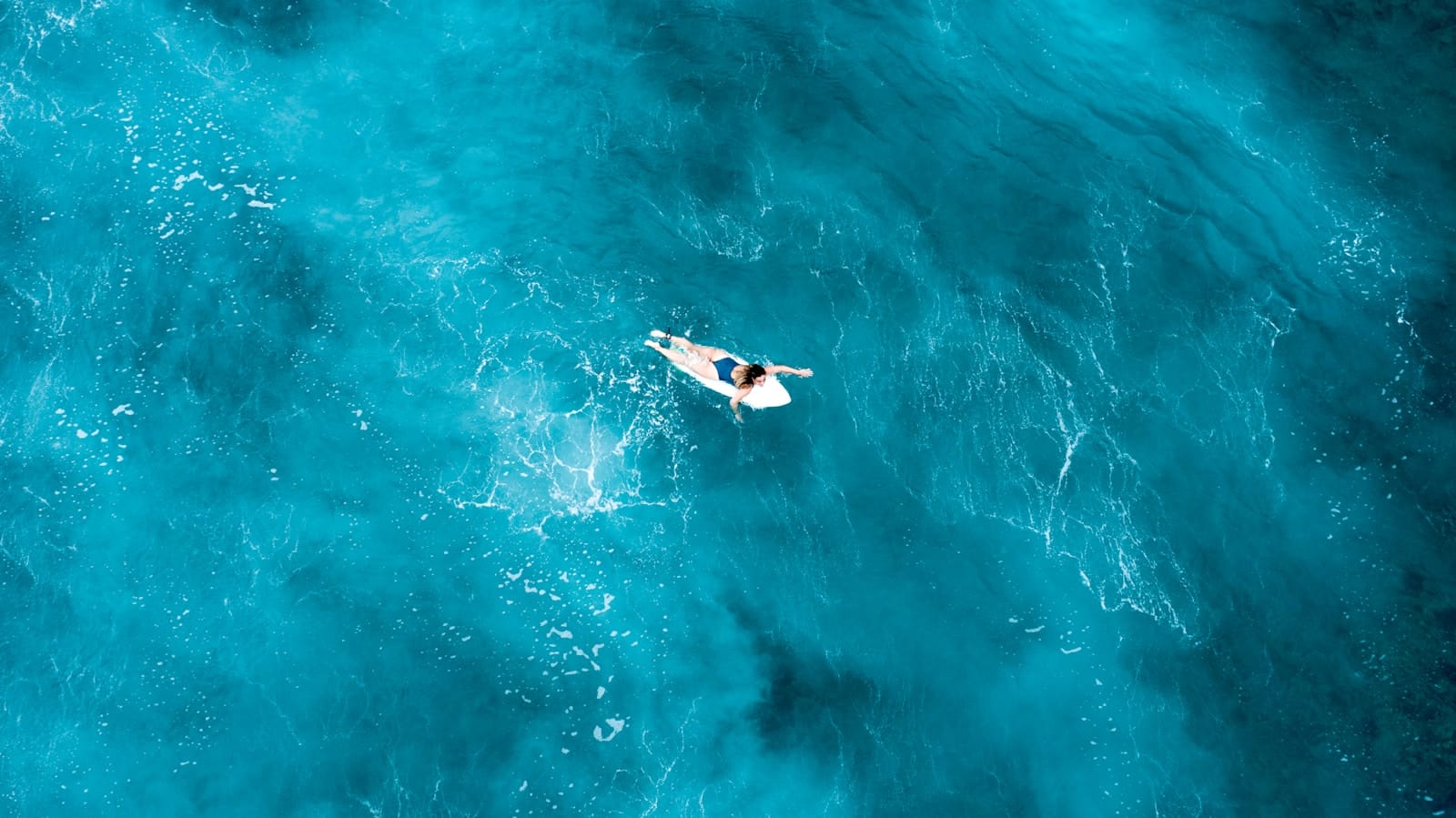 person on surfboard in midst of sea